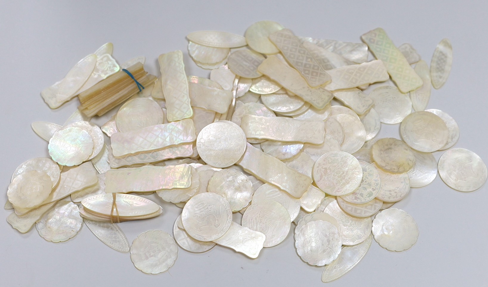 Approximately 135 Chinese carved mother of pearl counters of varying shapes, 19th century